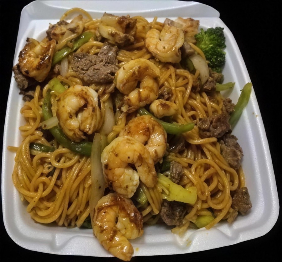 Hibachi noodles with shrimp, steak and vegetables in a to-go box